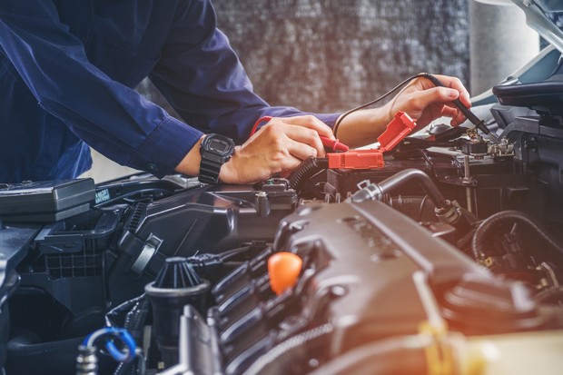 Hands of car mechanic working in auto repair service.